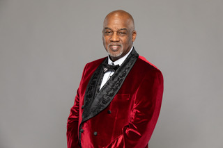 Pastor Glass in burgundy velvet jacket - wide shot