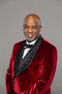 Pastor Glass in burgundy velvet jacket with bow tie